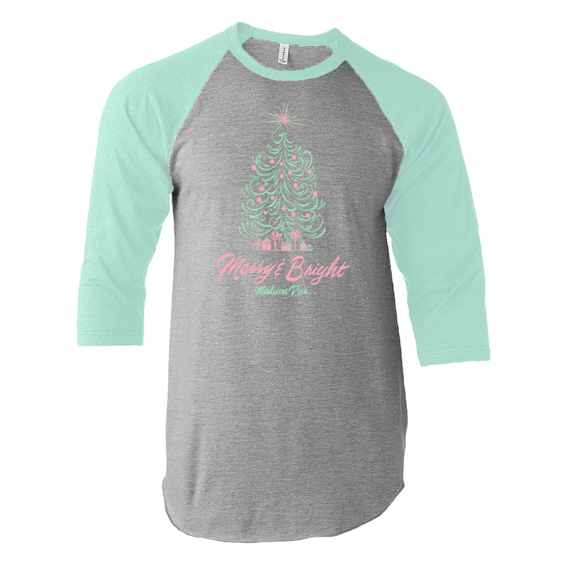 This cute women's Christmas shirt is adorned with an illustrated fat Christmas tree in green, with pink dots for ornaments. Under the tree are gifts and the phrase "merry and bright" in pink ink.