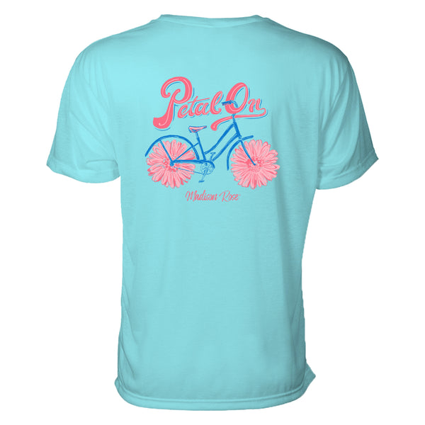 This cute women's t-shirt features a graphic design of a bicycle where the tires are actually flowers petals. Above the design are the words "Petal On." the colors are pinks and blues.