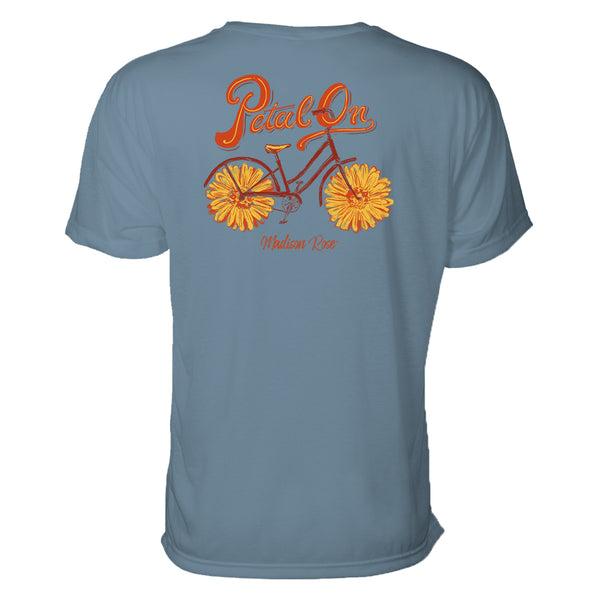 This cute women's t-shirt features a graphic design of a bicycle where the tires are actually flowers petals. Above the design are the words "Petal On." the colors are yellows and oranges. 