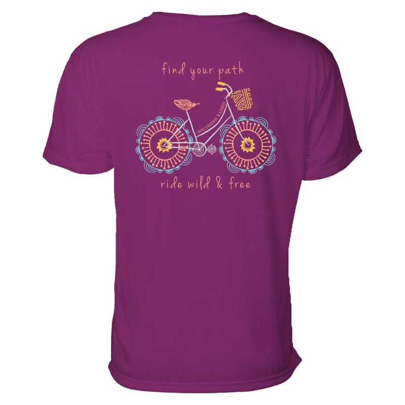 Southern t shirt slogan is "Find your path." Design is whimsical illustrated bicycle in light blue, pink and cantaloupe on a boysenberry t-shirt